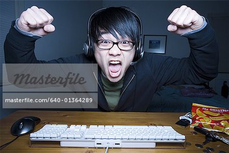 Mann mit Headset Fäuste machen und sitzen an der Tastatur