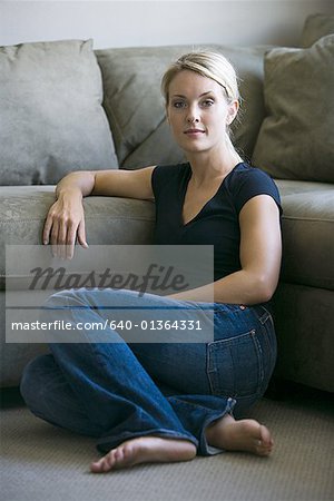 Portrait of a young woman sitting on the living room floor