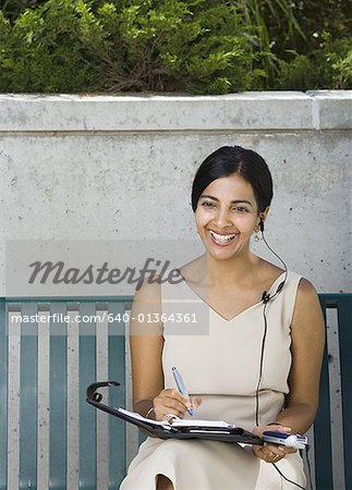 Femme d'affaires assis sur un banc et souriant