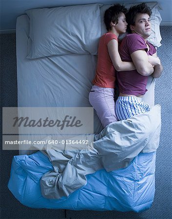 Dormir femme snuggling homme éveillé dans son lit