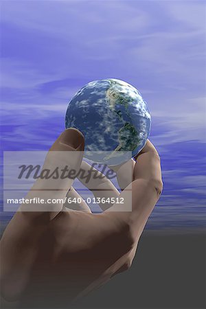 Low angle view of a globe in a person's hand