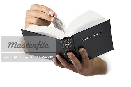 Gros plan des mains tenant une Bible de langue espagnole