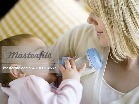 Woman holding baby with bottle