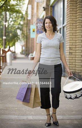 Mid adult woman walking with shopping bags