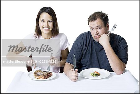 Portrait d'un jeune couple assis à la table