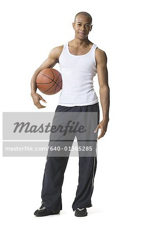 Portrait d'un jeune homme tenant un ballon de basket sous le bras
