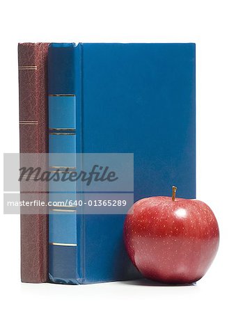 Close-up of an apple with two books