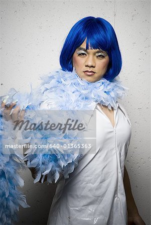 Man in blue wig and feather boa flirting