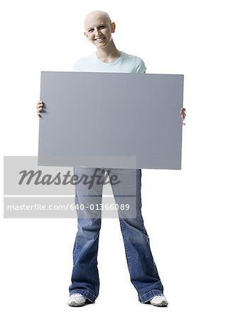 Portrait of a bald young woman holding a blank sign