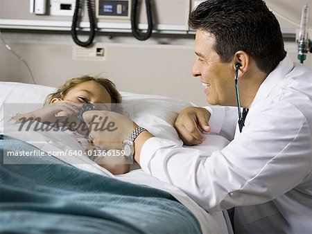 Doctor with stethoscope examining young girl in hospital