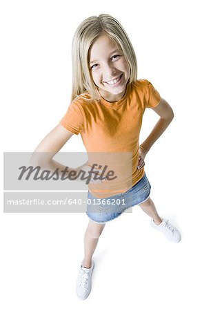 Portrait of a girl standing with her hands on her hips and smiling