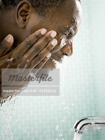 Gros plan d'un homme adult moyen laver son visage