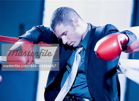 Close-up of a businessman sitting in a boxing ring