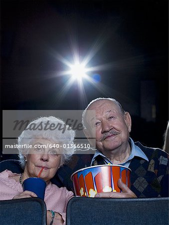 Man and woman watching movie with popcorn