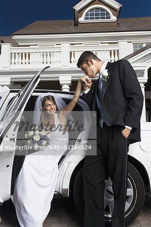 Marié baiser la main de sa fiancée et de sortir d'une voiture