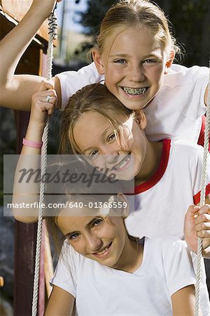 Portrait of three girls sitting on a swing