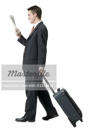 Profile of a businessman walking with luggage