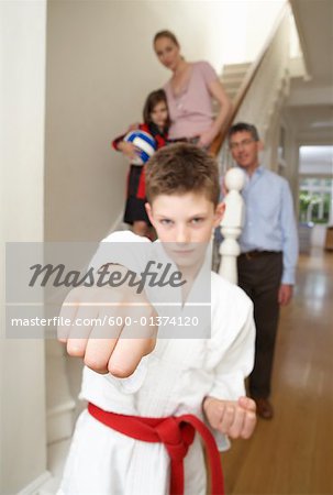 Boy in Karate Gi With Family in Background