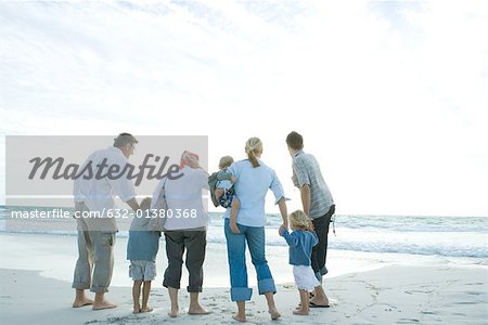 Three generation family standing on beach