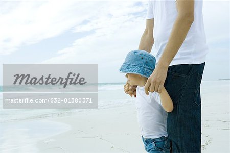 Man standing on beach with son