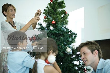 Family decorating Christmas tree