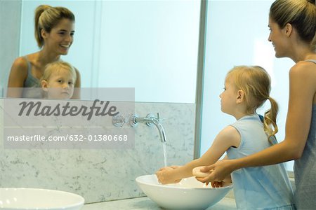 Mother and daughter washing hands together
