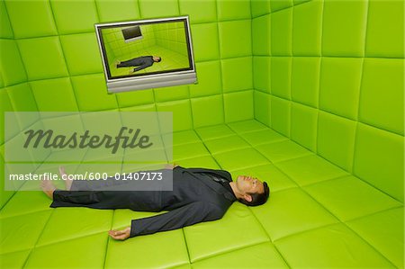 Homme couché sur le dos en vert chambre capitonnée avec Telelvision