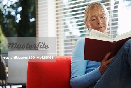 Femme lisant à l'intérieur