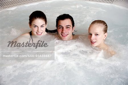 One man with two woman  in jacuzzi at a spa