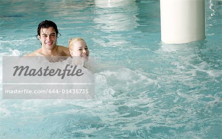 Jeune couple de nager dans la piscine thermale