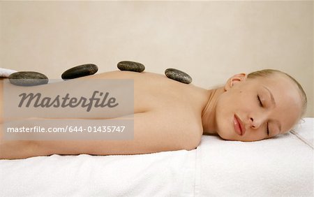Junge Frau genießen einen Massage mit heißen Steinen
