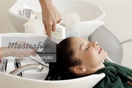 Jeune femme à avoir les cheveux lavé dans un salon