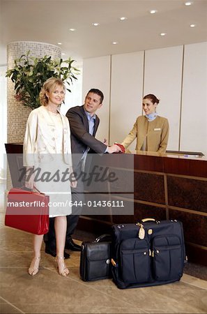 Couple checking in at hotel reception