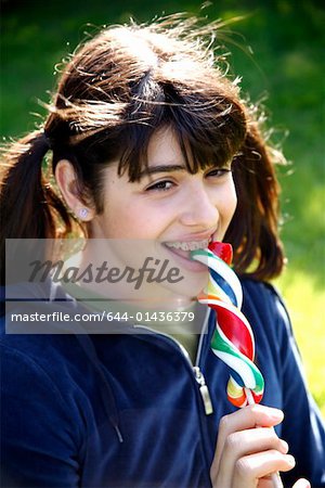 Teenage girl  licking a lollipop