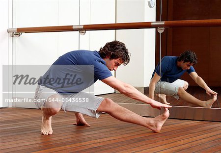 Young man stretching in gym