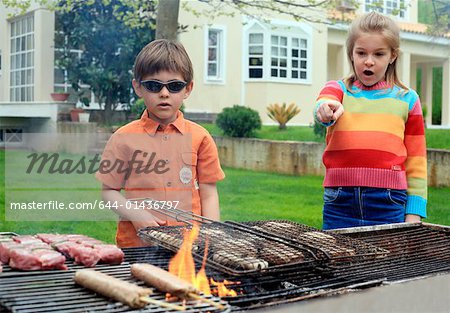 Boy and girl standing near a barbecue
