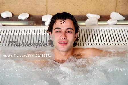 Jeune homme dans un jacuzzi, un spa