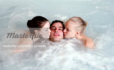 One man with two women  in jacuzzi at a spa