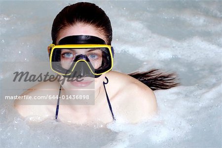 Eine Frau mit Maske im Whirlpool in einem spa