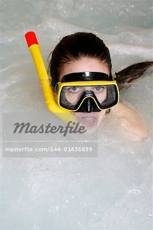 Une femme portant masque et tuba dans un jacuzzi, un spa