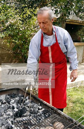 Älterer Mann Kochen Essen zu einem barbecue