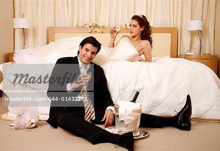 Bride and groom toasting in hotel room