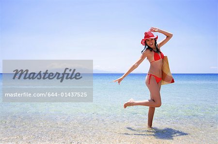 Jeune femme avec bikini, chapeau et sac de plage