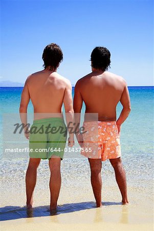 Deux hommes sur la plage face à la mer