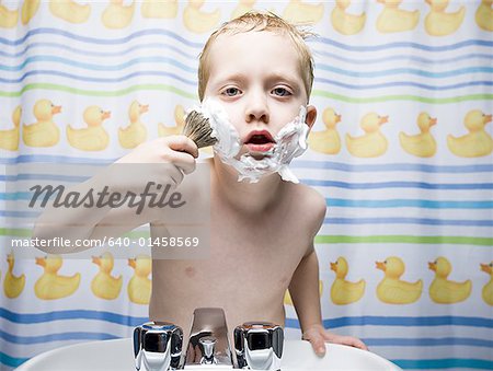 Garçon de rasage dans la salle de bain