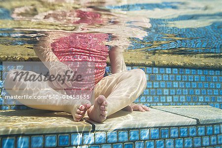 Jeune fille assise à la taille de la piscine