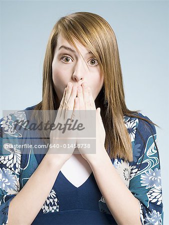 Woman with hands covering mouth surprised