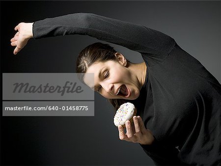 Woman stretching and about to eat donut