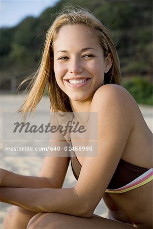 Frau im Bikini am Strand lächelnd