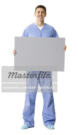 Male doctor or nurse holding blank sign smiling